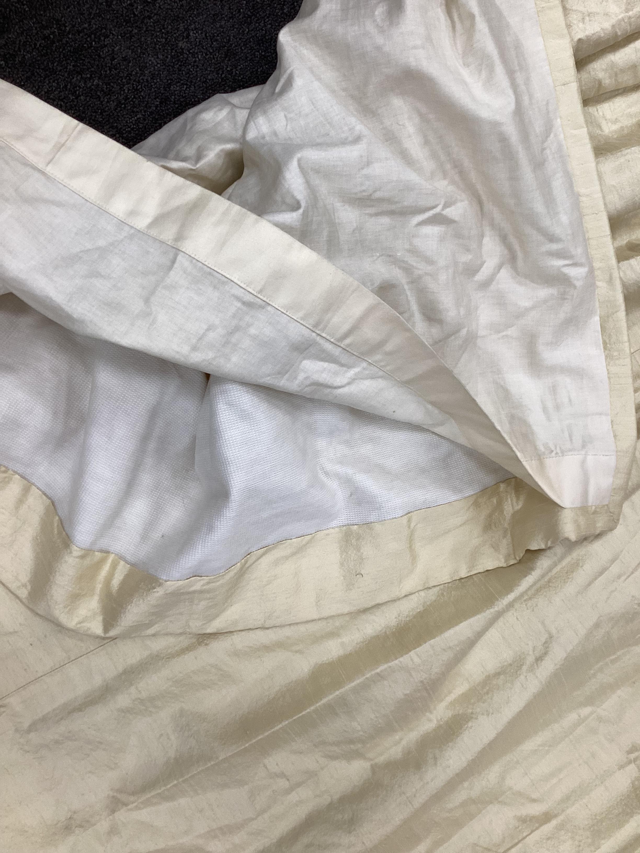 A pair of ivory coloured silk curtains, 137cm high